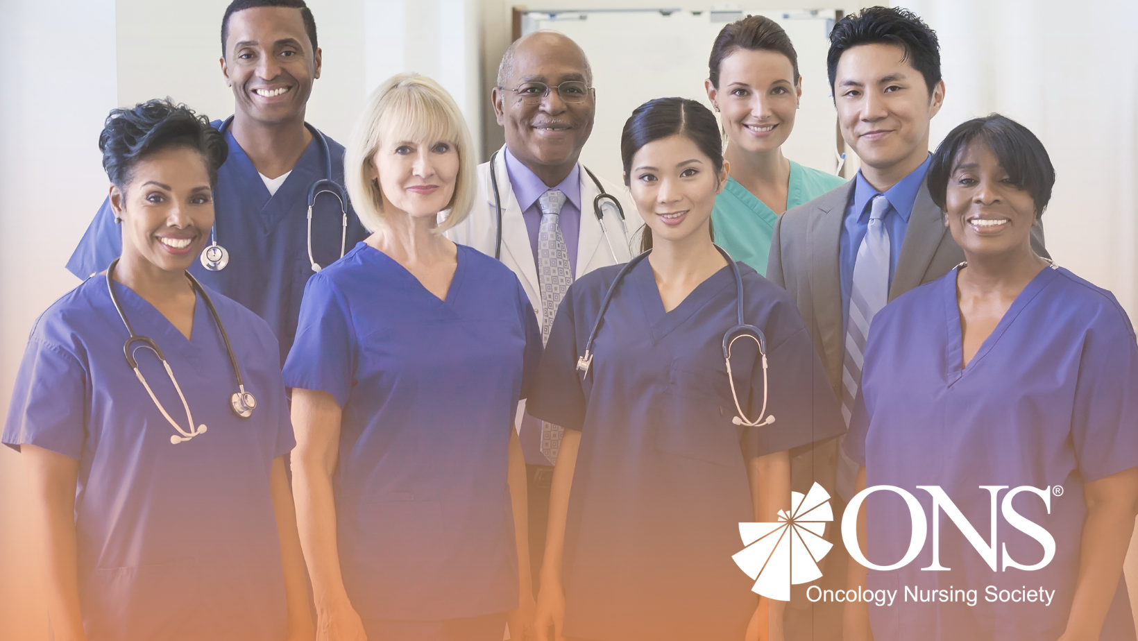 Group of smiling nurses in navy scrubs looking at the viewer